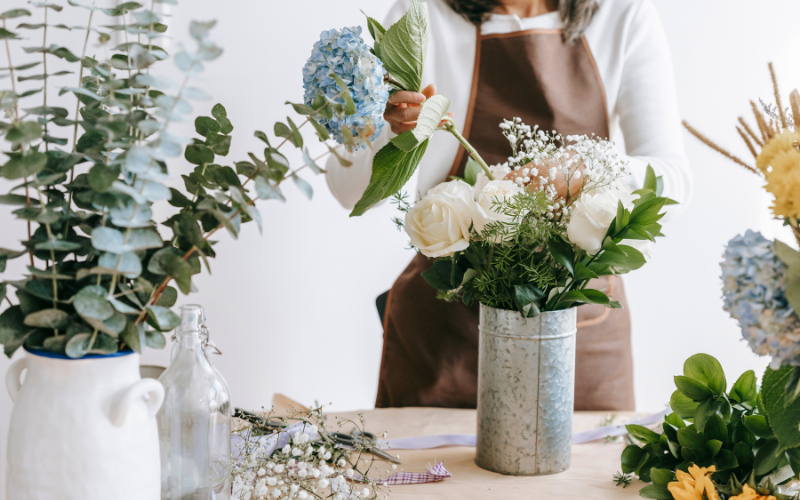 a woman holding a flower in a vase