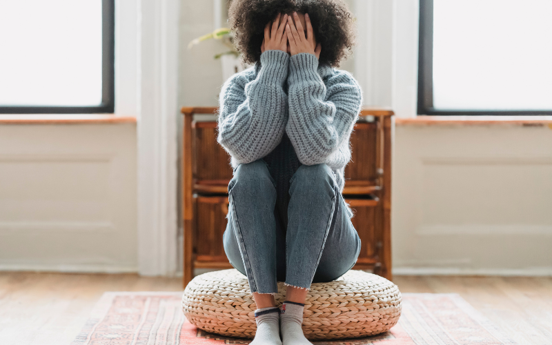 women sitting down with her hands on her face